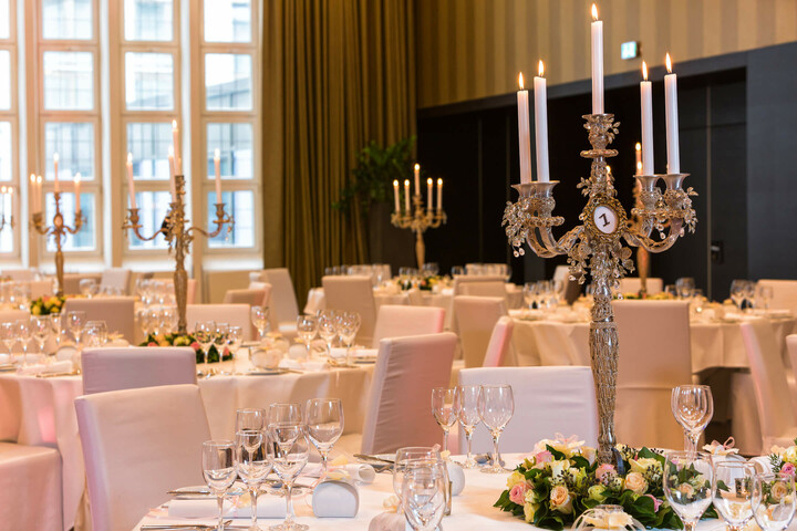 Goldener Saal Eleganter Bankettsaal mit weiß gedeckten Tischen, Blumenarrangements und silbernen Kerzenleuchtern im ATLANTIC Grand Hotel Bremen.