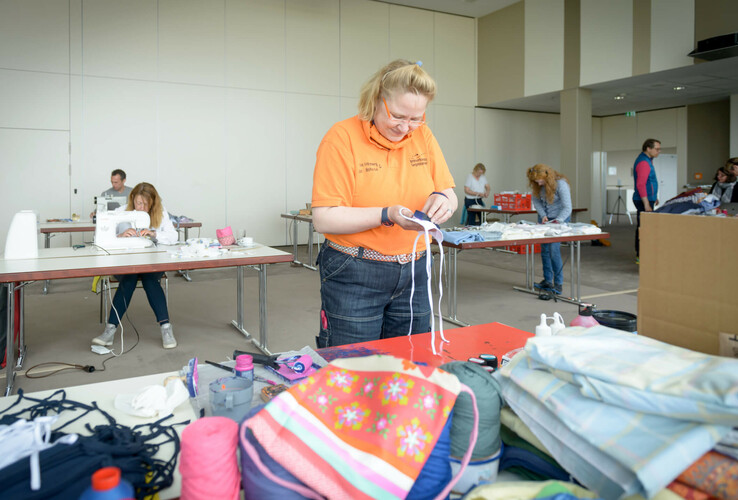 Personen nähen und arbeiten an Tischen in einem hellen Raum des ATLANTIC Hotel Sail City.