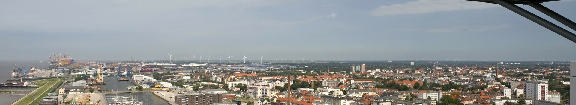 View from the observation desk of the ATLANTIC Hotel SAIL City View from the viewing platform of the ATLANTIC Hotel Sail City over Bremerhaven, with harbor, buildings and wind turbines in the background.
