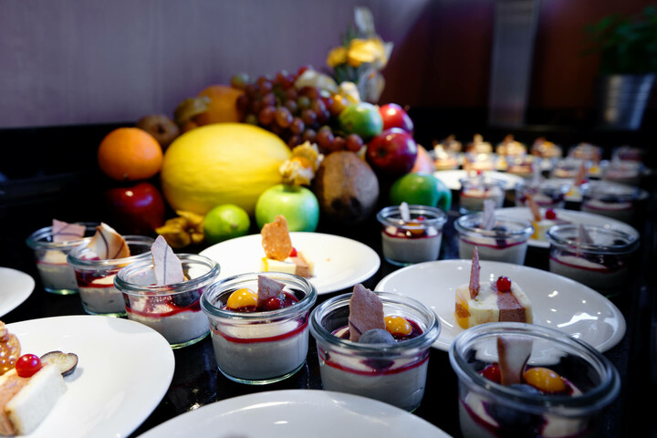 Dessertbuffet mit frischen Früchten und kleinen Gläsern mit Panna Cotta, dekoriert mit Beeren und Gebäck im ATLANTIC Hotel.