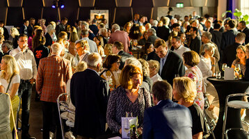 Menschen bei einem geselligen Empfang im Veranstaltungsraum des ATLANTIC Hotel Münster.