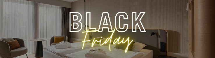 Modernes Hotelzimmer mit Doppelbett, Schreibtisch, Sessel, großem Fenster; Text: "Black Friday".