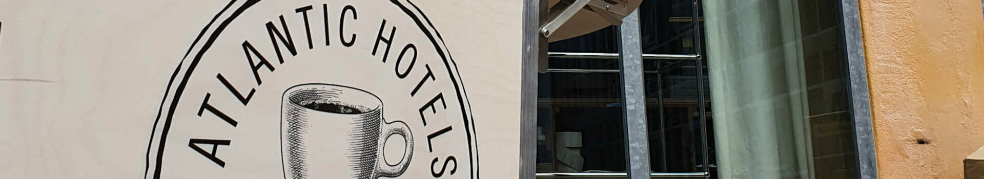 Coffee wheel of the ATLANTIC Hotel Münster in front of a window with a yellow wall in the background.