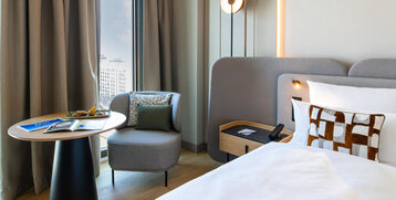 Armchair with side table and bed in the Skyline room.