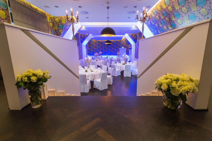 Eleganter Festsaal im ATLANTIC Grand Hotel Bremen mit gedeckten Tischen, Kerzenleuchtern und Blumenarrangements.