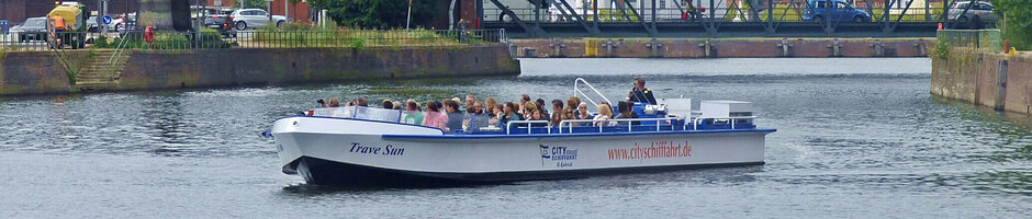 Boat on the river Trave in front of the red tower and bridge in Lübeck, near the ATLANTIC Hotel.