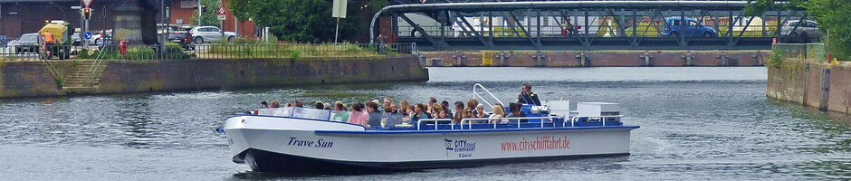 Boot auf der Trave vor rotem Turm und Brücke in Lübeck, nahe dem ATLANTIC Hotel.