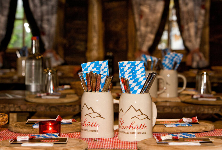 Bavarian beer mugs on display in the cosy, rustic restaurant with wooden tables.