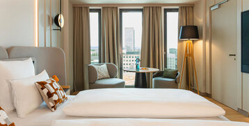 Ausblick auf die Sitzecke und die Frankfurter Skyline vom Bett aus.