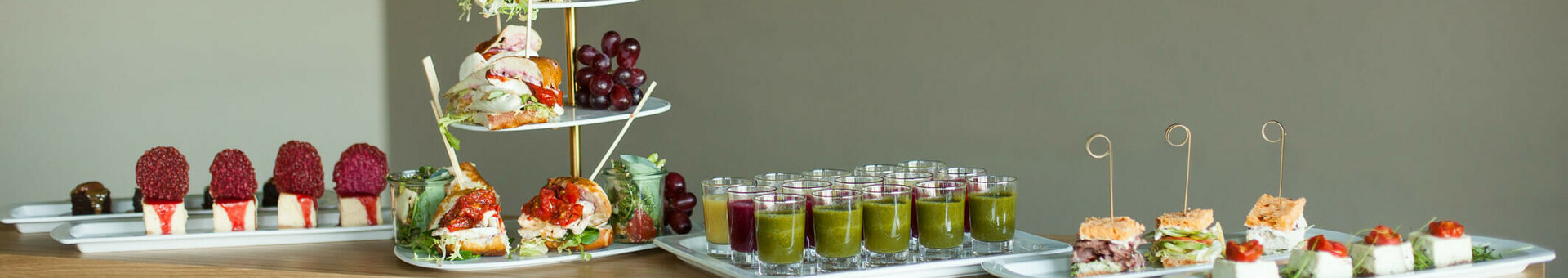 Buffet mit belegten Brötchen, Obst und bunten Getränken im ATLANTIC Hotel Airport Bremen, im Hintergrund Flugzeugbild.