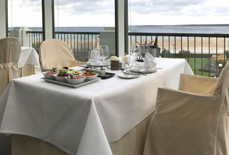 Elegant gedeckter Tisch mit Meerblick im ATLANTIC Grand Hotel Travemünde.