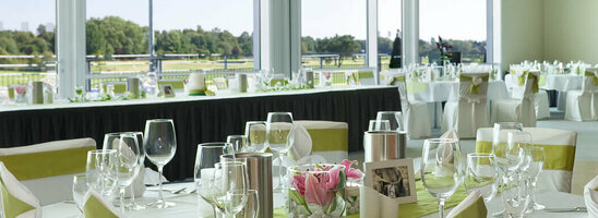 Eleganter Bankettsaal im ATLANTIC Hotel Galopprennbahn, Bremen, mit gedeckten Tischen und Blick auf die Rennbahn.