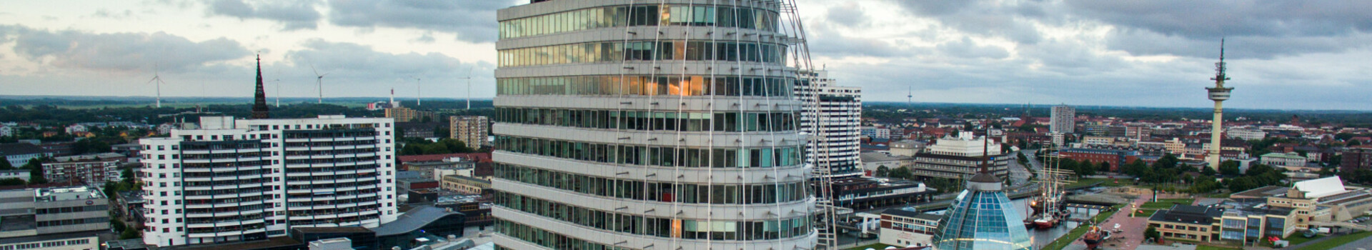 Gesicherte Nachhaltigkeit - ATLANTIC Hotel Sail City Bremerhaven Modernes Hochhaus des ATLANTIC Hotel Sail City in Bremerhaven, mit Blick auf die Stadt und die Weser.
