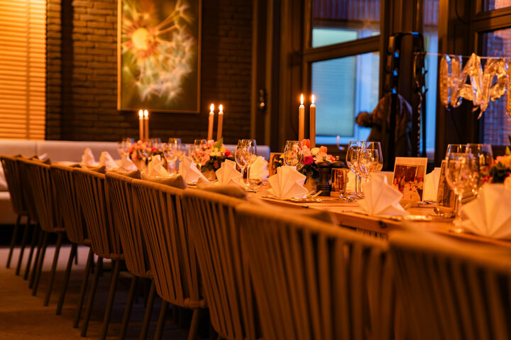 Festlich eingedeckte Tafel mit Blumen und Kerzen im Wintergarten.