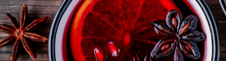 Two mugs with red mulled wine and a slice of orange