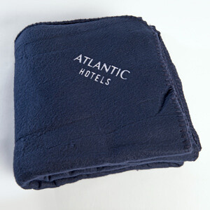 Decke  Gefaltete dunkelblaue Decke mit gesticktem "Atlantic Hotels" Schriftzug darauf.