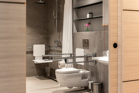 Barrierefreies Badezimmer im ATLANTIC Hotel Heidelberg mit Haltegriffen, Duschsitz und moderner Ausstattung.