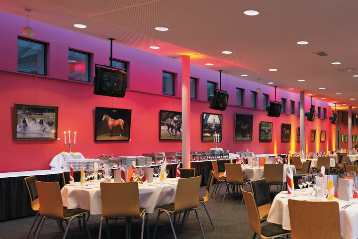 Enjoy your evening in the turflounge of the ATLANTIC Hotel Galopprennbahn Elegant dining room in the ATLANTIC Hotel, decorated with pictures of horses, laid tables and atmospheric lighting.