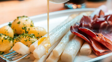 Leckerer Spargel, Petersilienkartoffeln und geräucherter Schinken im Restaurant CHALET