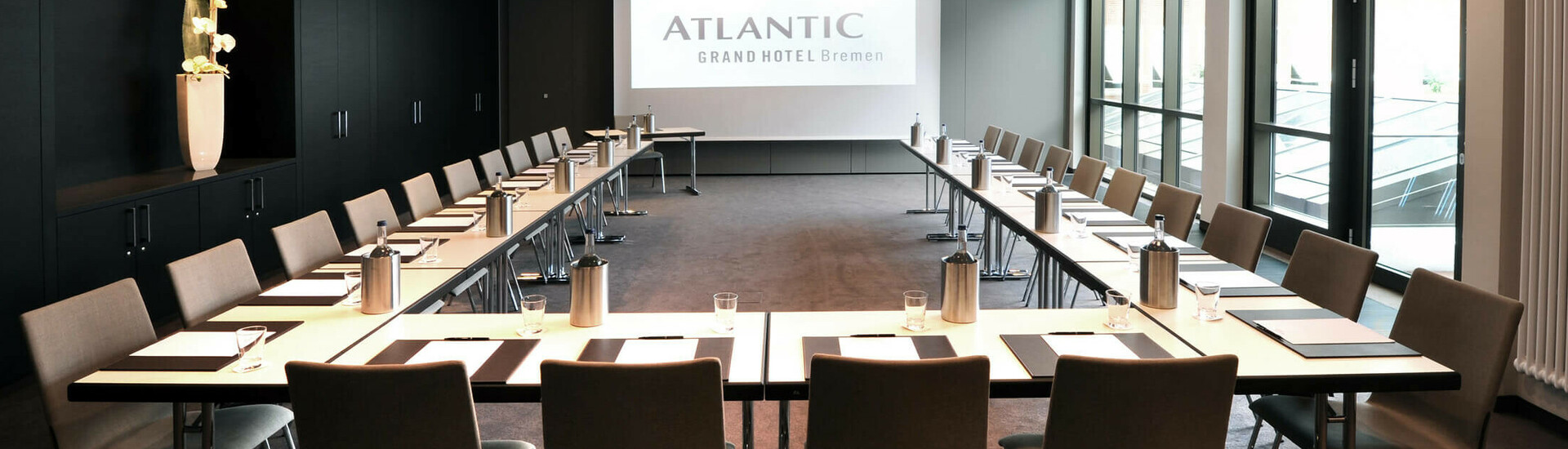 Moderner Konferenzraum im ATLANTIC Grand Hotel Bremen mit U-förmiger Bestuhlung und Tageslicht.