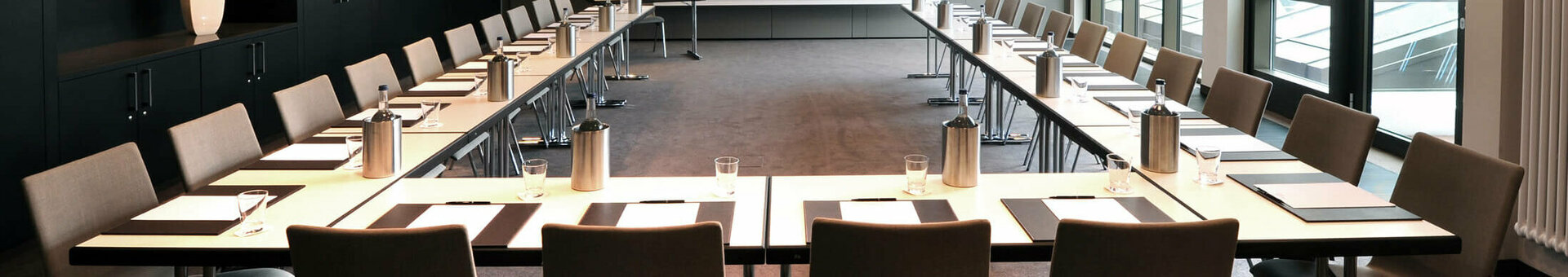 Moderner Konferenzraum im ATLANTIC Grand Hotel Bremen mit U-förmiger Bestuhlung und Tageslicht.