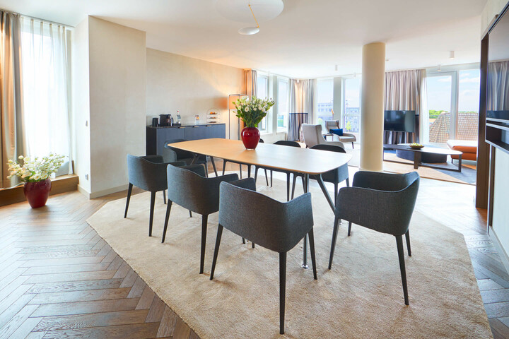 Helle Suite im ATLANTIC Grand Hotel Bremen mit Esstisch, modernen Stühlen, großen Fenstern und stilvoller Einrichtung.