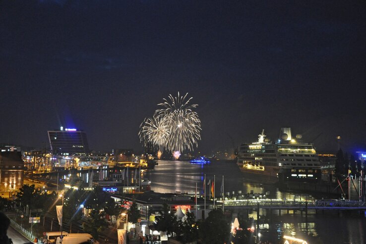 View of Kiel harbor at night with fireworks and illuminated cruise ship, near the ATLANTIC Hotel Kiel.