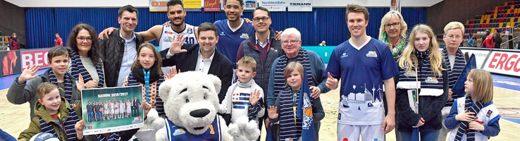 ATLANTIC Hotel SAIL City Bremerhaven Pressemitteilung Gruppe von Menschen und Maskottchen auf einem Basketballfeld, lächelnd und posierend für ein Foto.