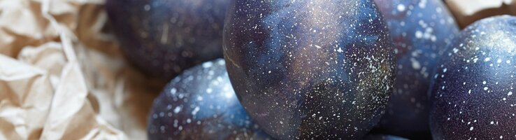 Dark blue Easter eggs lie on brown wrapping paper.