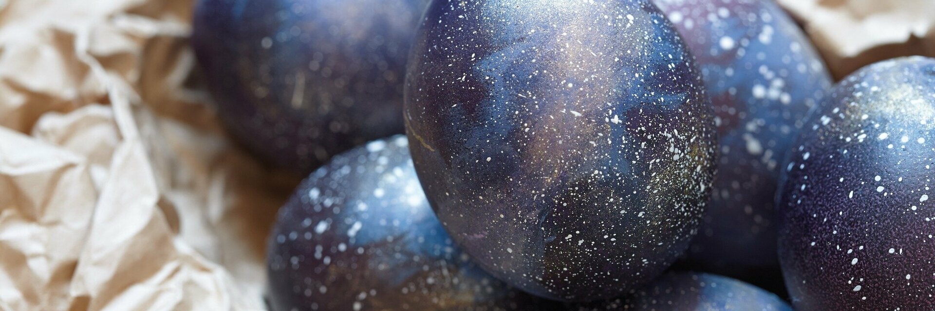 Dark blue Easter eggs lie on brown wrapping paper.