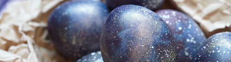 Dunkelblau gefärbte Ostereier liegen auf braunem Packpapier.