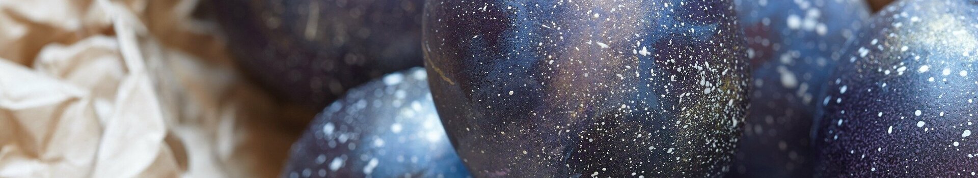 Dark blue Easter eggs lie on brown wrapping paper.