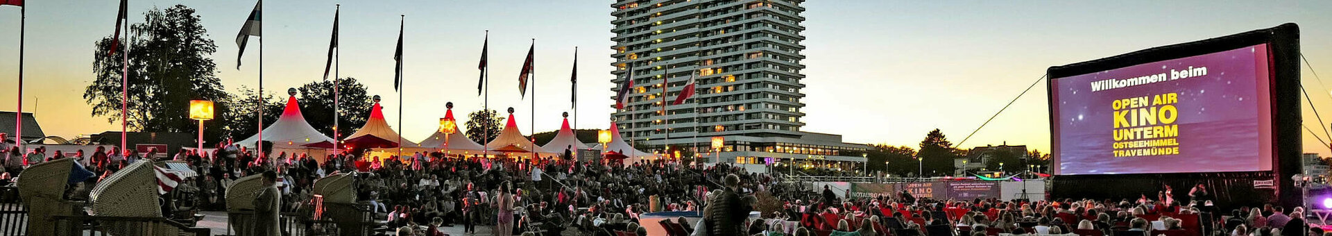 Kino unterm Ostseehimmel in Travemünde Open-Air-Kinoabend am Strand vor dem ATLANTIC Grand Hotel Travemünde bei Sonnenuntergang, viele Besucher auf Decken.