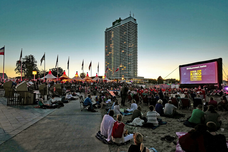 Open-Air-Kinoabend am Strand vor dem ATLANTIC Grand Hotel Travemünde bei Sonnenuntergang, viele Besucher auf Decken.