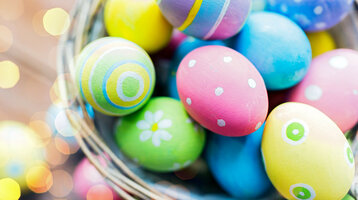 Ostereier | Gutschein-Shop der ATLANTIC Hotels Bunte, bemalte Ostereier in einem Korb mit fröhlichen Mustern und frühlingshaftem Flair.
