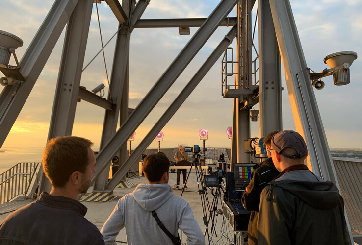 Menschen filmen den Sonnenuntergang auf dem Dach des ATLANTIC Hotel Sail City in Bremerhaven.