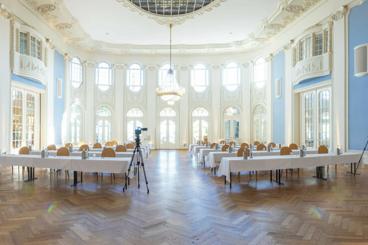 Eleganter, heller Konferenzraum mit hohen Decken, Kronleuchter und Fenstern im ATLANTIC Grand Hotel Travemünde.