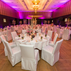Eleganter Bankettsaal im ATLANTIC Grand Hotel Bremen, festlich gedeckte runde Tische mit weißen Stühlen und Kerzenleuchtern.