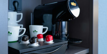 Kaffeemaschine mit Kapseln und Tassen im ATLANTIC Hotel Landgut Horn Bremen.