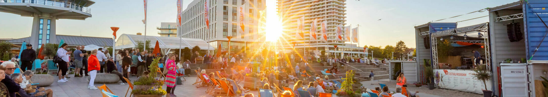 ATLANTIC Hotel Travemünde Seebad-Kulturfestival Abendstimmung Sonnenuntergang, Menschen entspannen in Liegestühlen auf einer Terrasse.