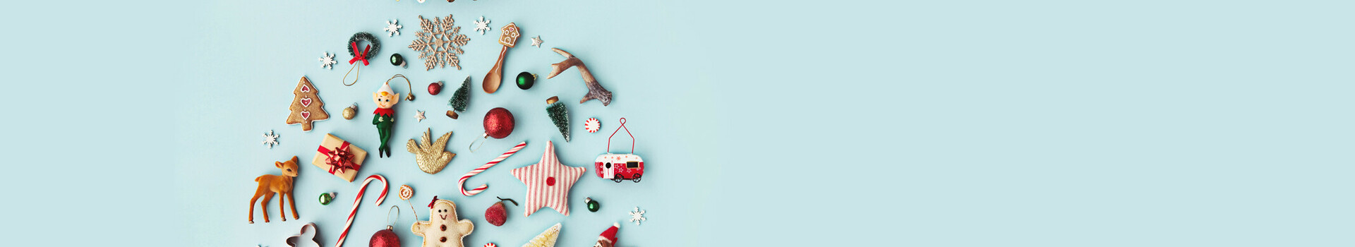 Christmas decorations and cookies form a ball on a light blue background.