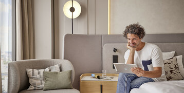 Guest with an iPad in the hotel room of the ATLANTIC Hotel Frankfurt