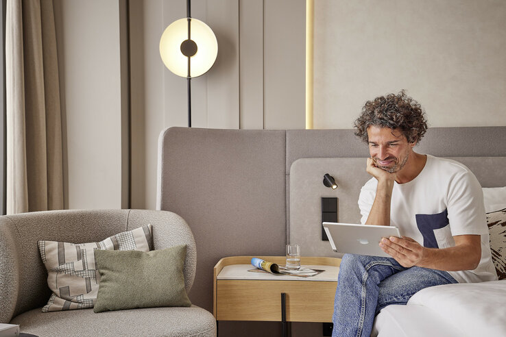 Guest with an iPad in the hotel room of the ATLANTIC Hotel Frankfurt
