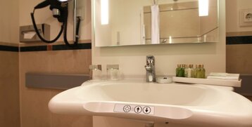 Waschbecken mit Bedienelementen für berrierefreien Zugang des Standard Zimmer barrierefrei im ATLANTIC Hotel Wilhelmshaven