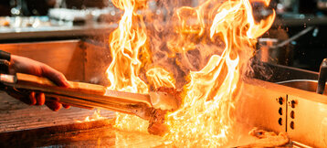 Flammen auf dem Grill im ATLANTIC Grillroom Münster