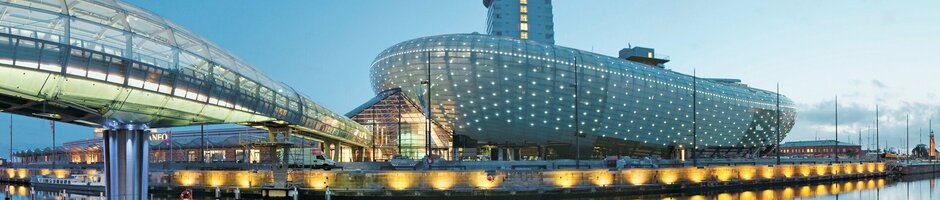 Futuristic building of the ATLANTIC Hotel Sail City in Bremerhaven, illuminated and located on the waterfront.