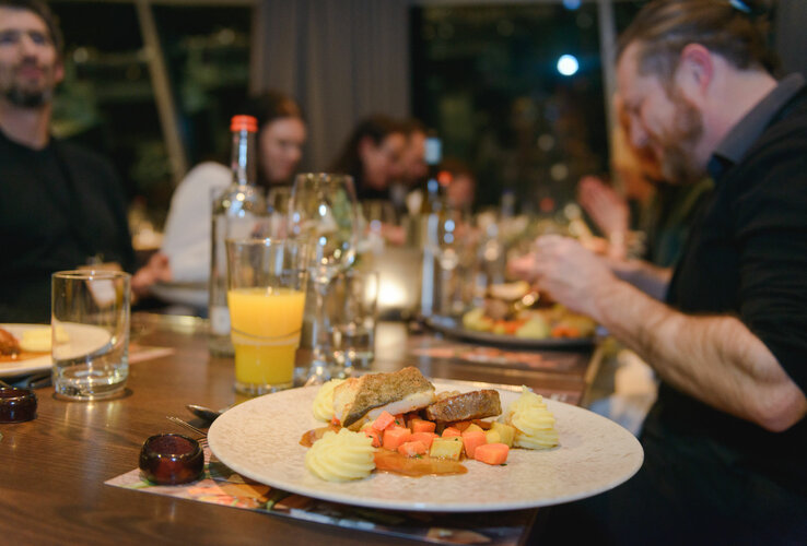 Guests enjoy an elegant dinner with fish and vegetables in the ATLANTIC Hotel Sail City Restaurant.