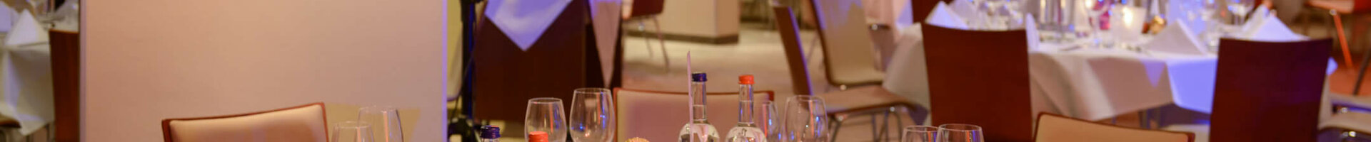 Elegantes Hotelrestaurant mit festlich gedeckten Tischen, weißen Tischdecken und sanfter Beleuchtung im ATLANTIC Hotel Sail City.