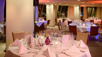 Christmas party on DECK 1 Elegant hotel restaurant with festively laid tables, white tablecloths and soft lighting at the ATLANTIC Hotel Sail City.