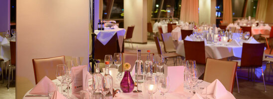 Elegant hotel restaurant with festively laid tables, white tablecloths and soft lighting at the ATLANTIC Hotel Sail City.